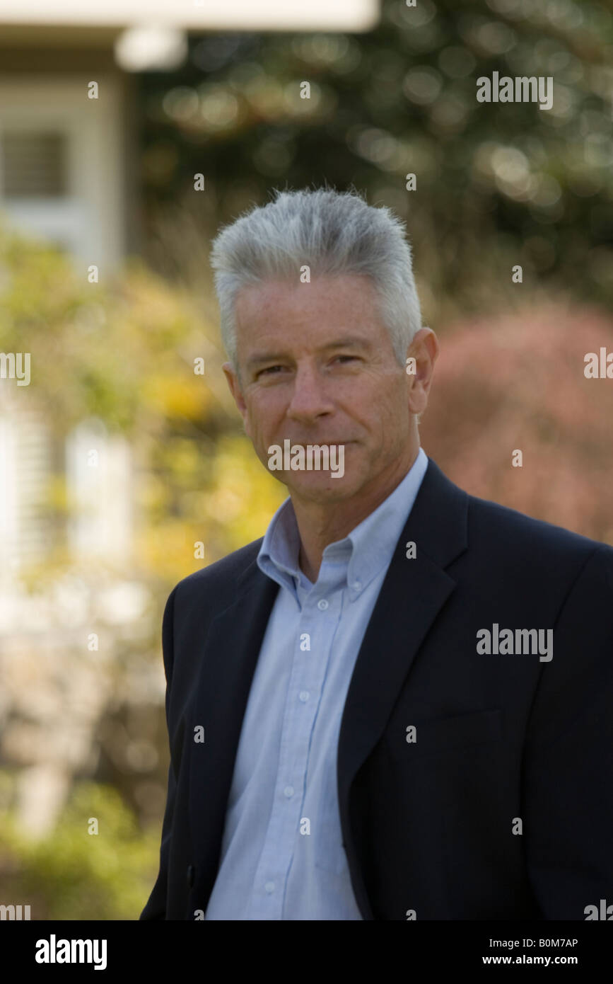 Ritratto di un agente immobiliare in piedi all'aperto in un quartiere residenziale Foto Stock