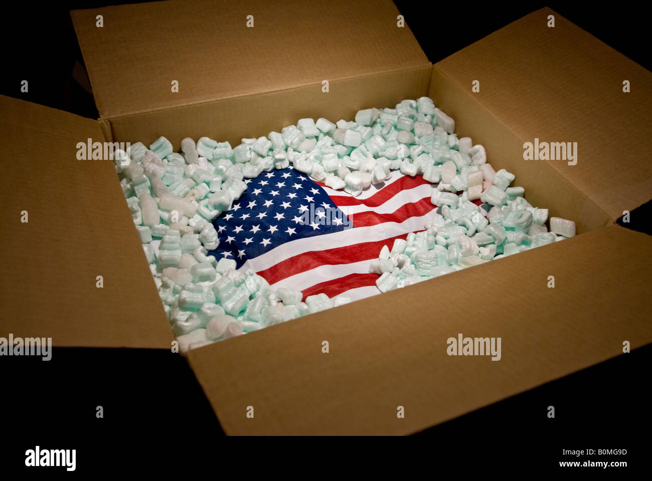 American bandiera degli Stati Uniti nel cartone di spedizione parzialmente ricoperta con il materiale di imballaggio Foto Stock