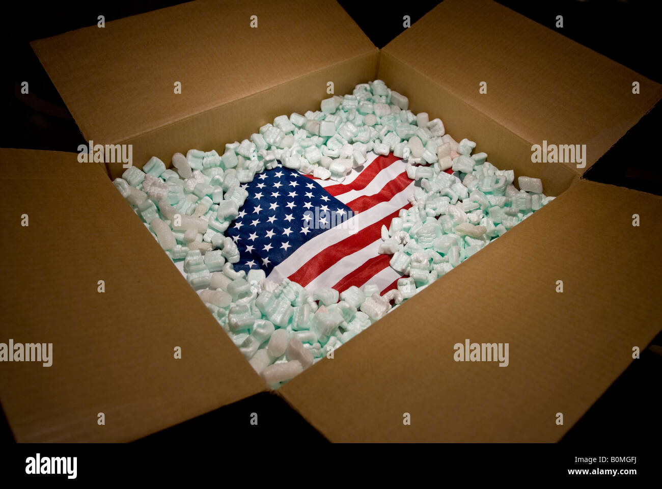 American bandiera degli Stati Uniti nel cartone di spedizione parzialmente ricoperta con il materiale di imballaggio Foto Stock