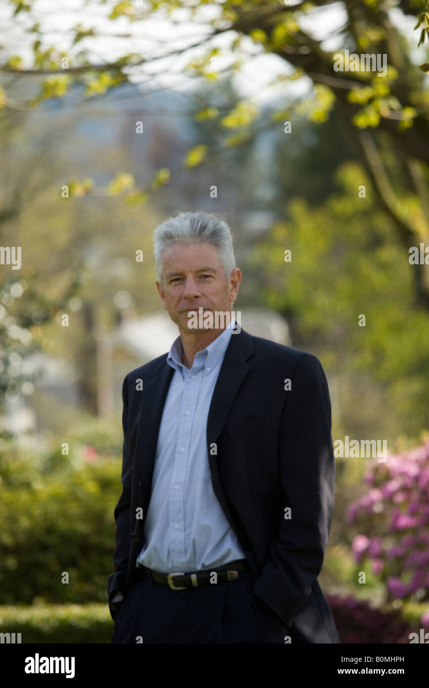 Ritratto di un agente immobiliare in piedi all'aperto in un quartiere residenziale Foto Stock
