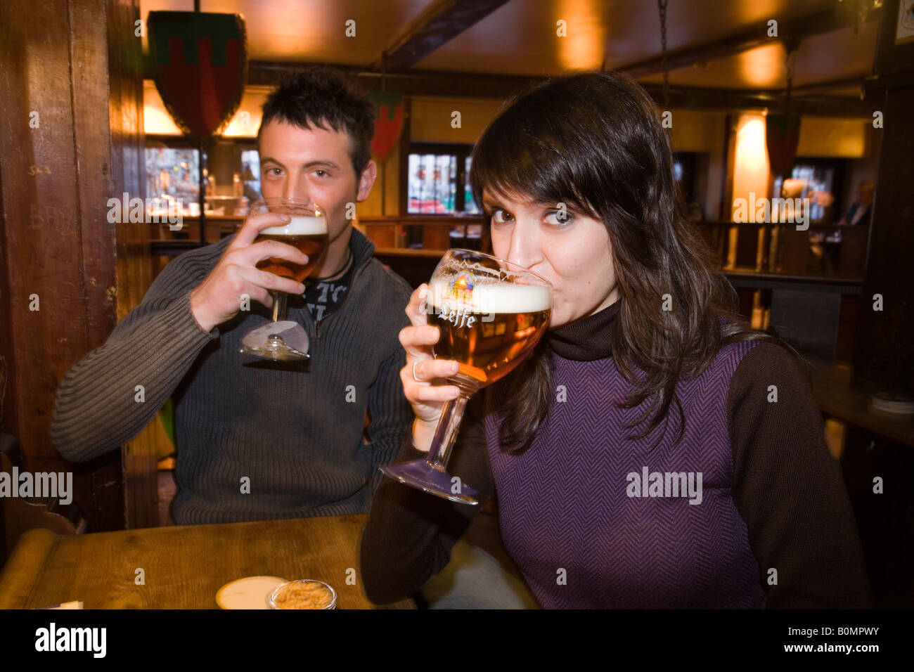 Coppia giovane a bere una birra belga nel Le Roy d'Espagne bar. La Grand Place di Bruxelles. Belgio Foto Stock