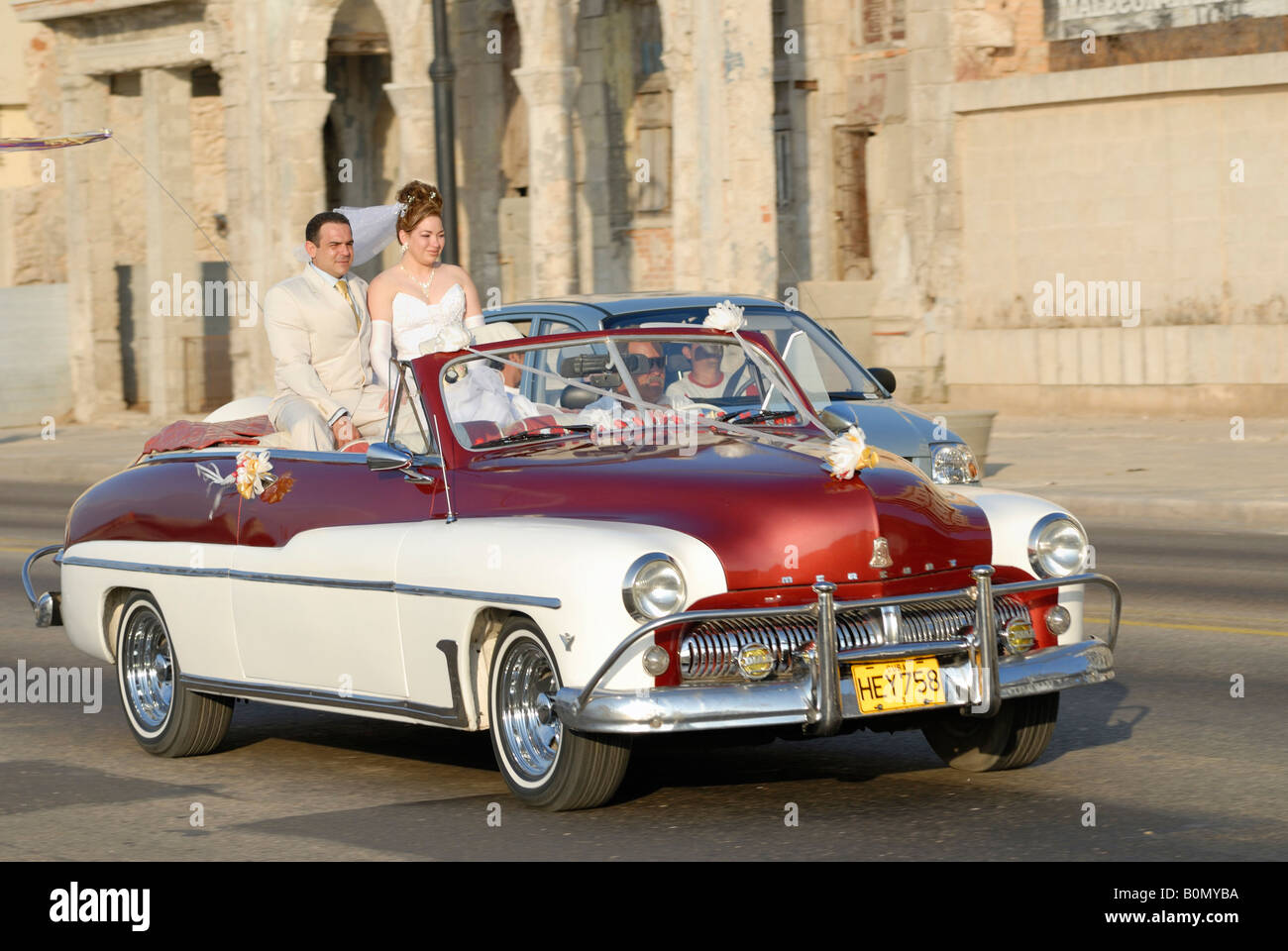 Una coppia di sposi la guida in un vintage americano auto sul Malecon strada in Havana Cuba Aprile 2007 Foto Stock