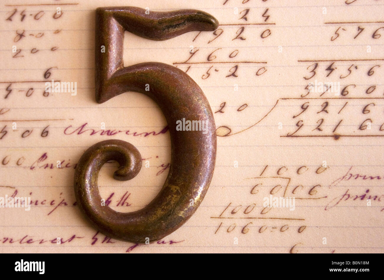 Un metallo numero 5 nella foto su carta contenente altri numeri e operazioni matematiche. Foto Stock