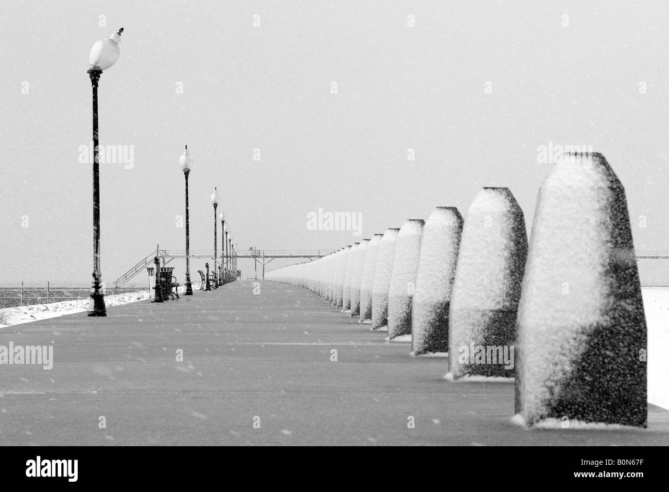 Nevicata sul marciapiede, pier e tralicci presso il Lago Michigan Foto Stock