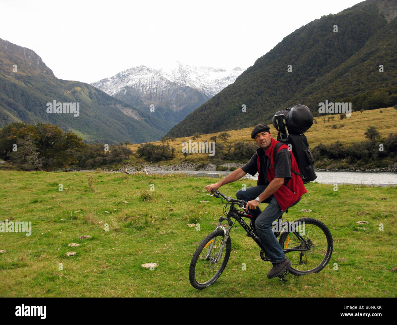 Un uomo in berretto su una mountain bike in Nuova Zelanda alpi del sud Foto Stock