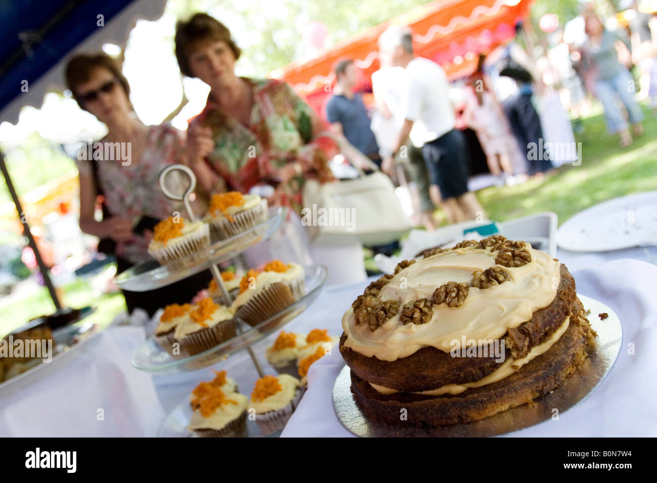 I clienti a una torta in stallo durante una Summer Fair di Dulwich, a sud di Londra. Foto Stock