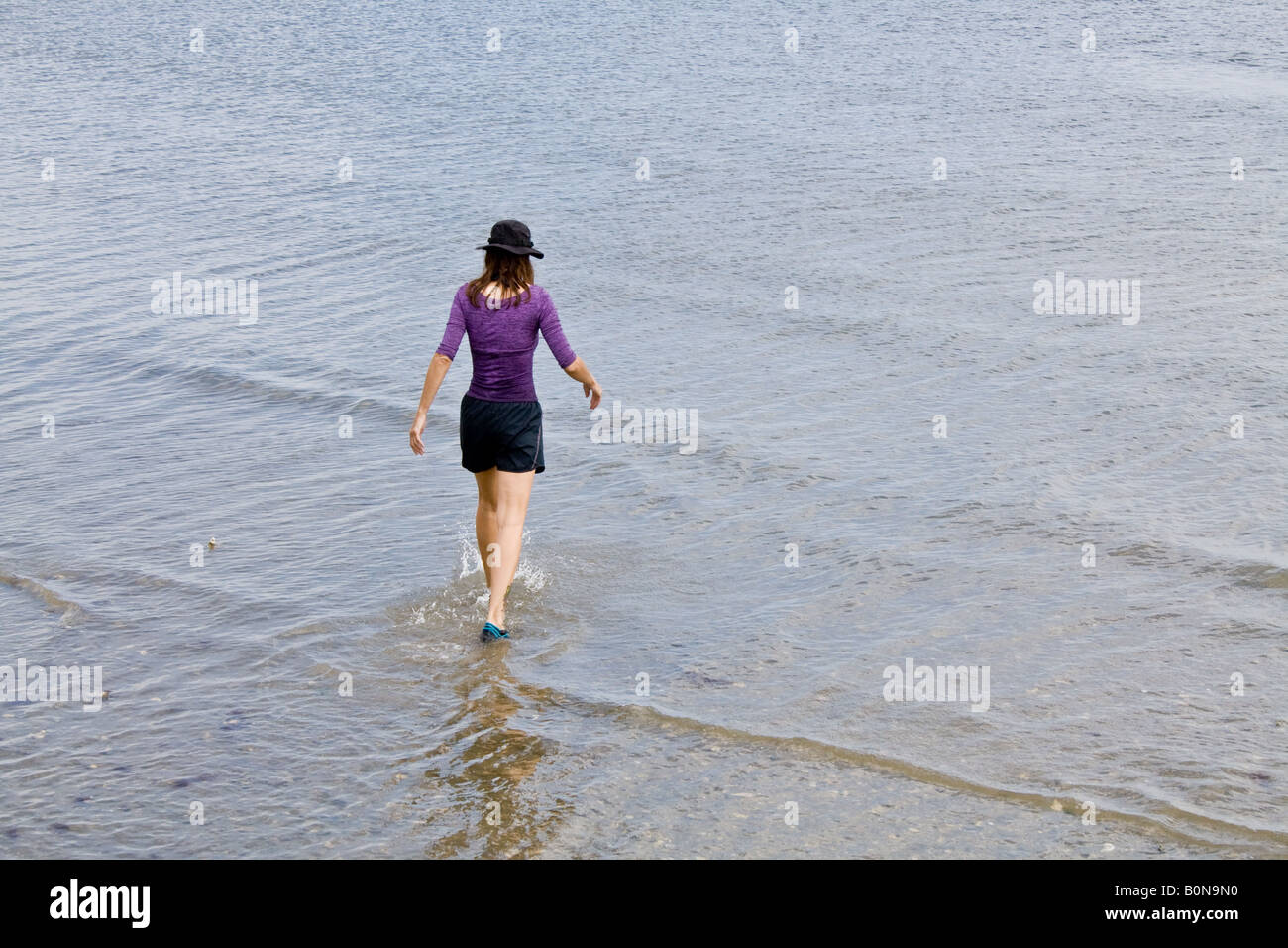 Una ragazza, completamente vestito, paddling in Matanzas River a St Augustine Florida, Stati Uniti d'America. Foto Stock