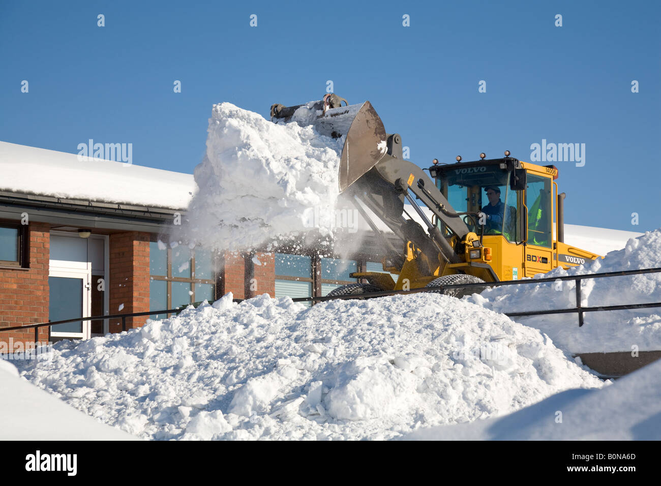 Un caricatore a estremità anteriore cancella masse di neve a Kiruna / Svezia settentrionale Foto Stock