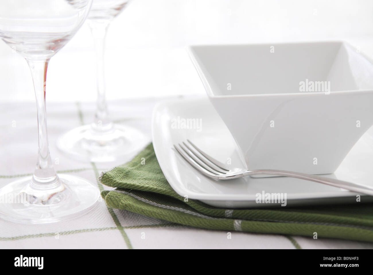 Posizionare l'impostazione bianco con piatti e bicchieri di vino Foto Stock