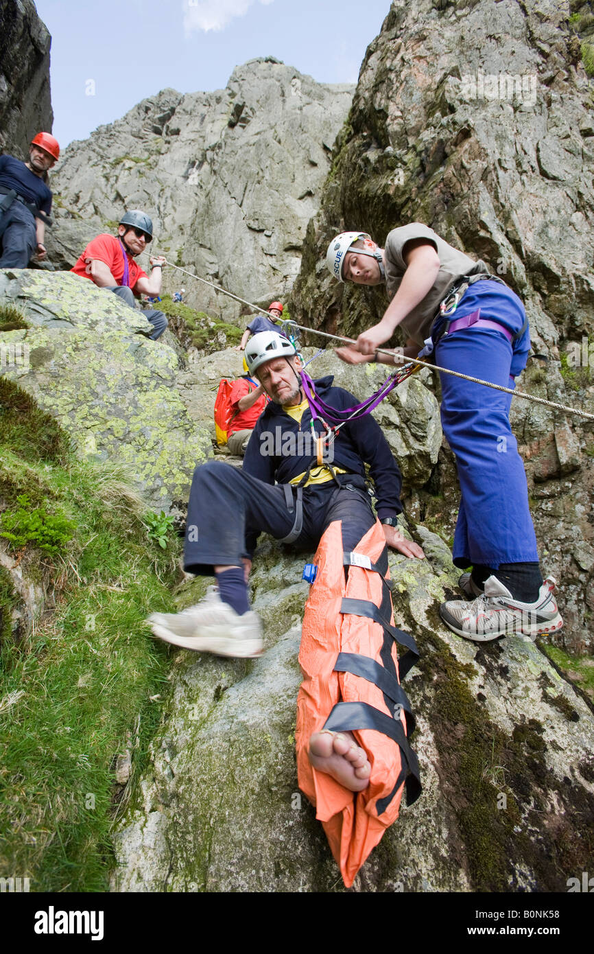 I membri di Langdale Ambleside Mountain Rescue Team il salvataggio di un alpinista caduto con una gamba rotta Foto Stock