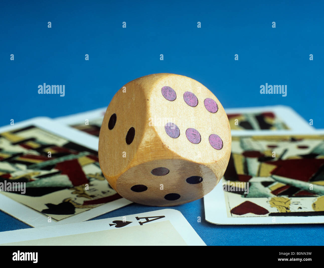 Studio di vita ancora morire in legno e carte da gioco su sfondo blu in stretta fino che mostra sei macchie e asso di picche Foto Stock
