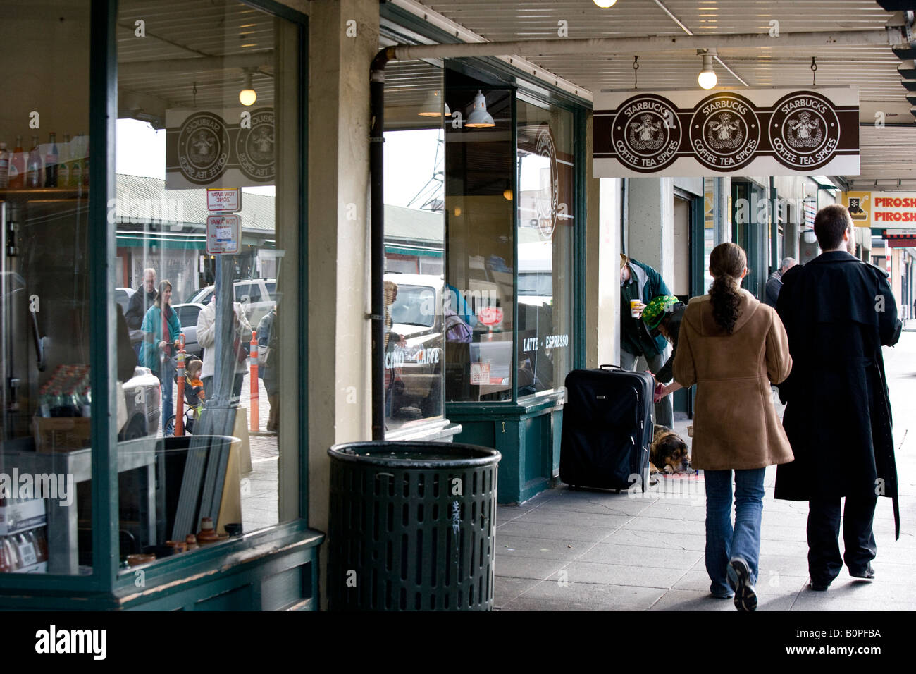 Giovane a piedi nella parte anteriore originale di Starbucks Coffee shop, Seattle Washington, Stati Uniti d'America Foto Stock