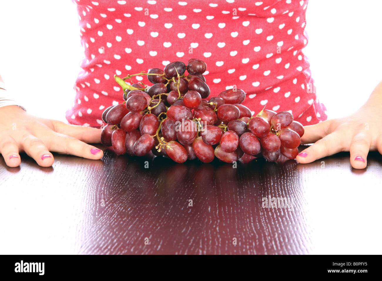 Giovane donna con uve rosse Modello rilasciato Foto Stock