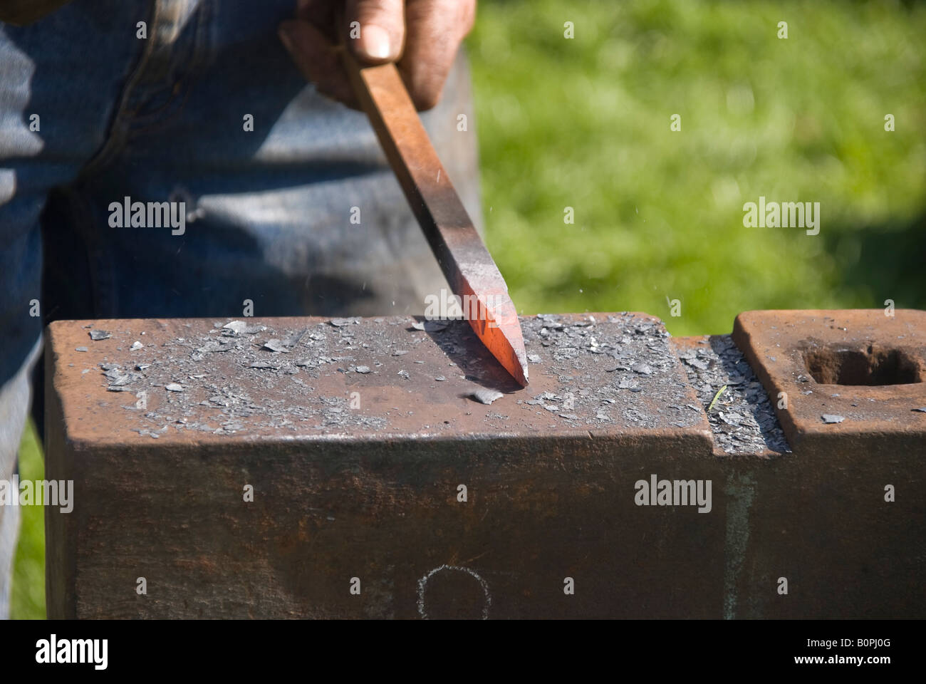 Fabbro si prepara a forma red hot-barra di ferro su una incudine Foto Stock