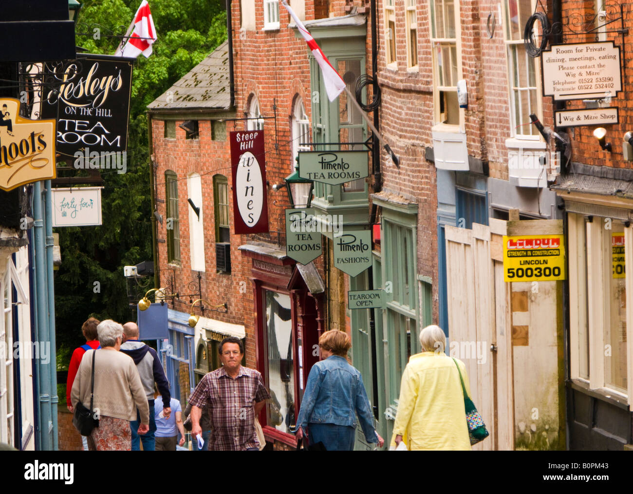 I turisti scendendo ripida collina nell'antica città vecchia passato una tradizionale sala da tè in Lincoln, England, Regno Unito Foto Stock