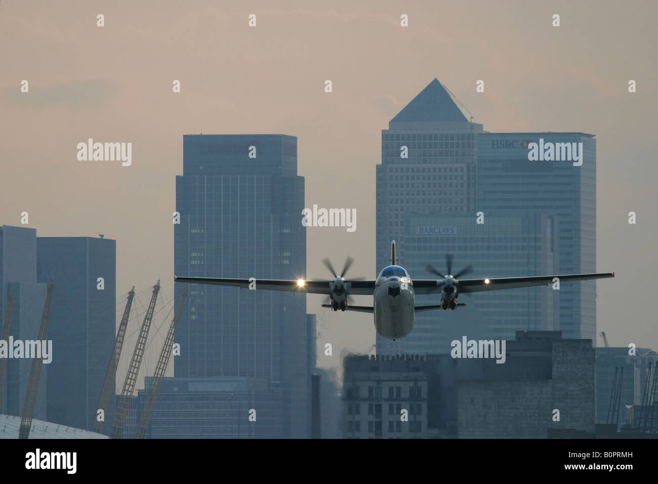 Aereo in fase di decollo all'Aeroporto di London City con Canary Wharf in background Londra Inghilterra REGNO UNITO Foto Stock