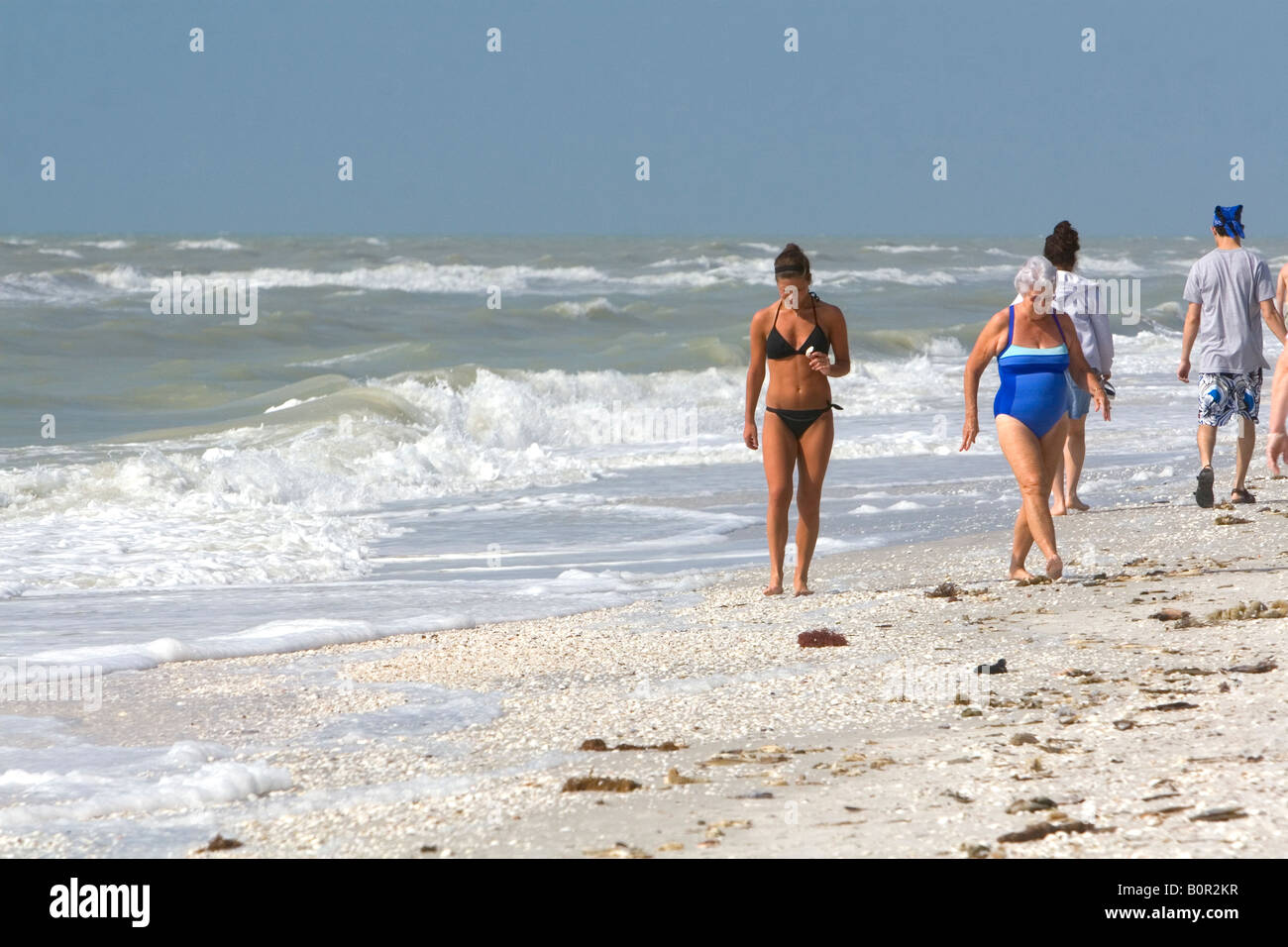 Beachcombers alla ricerca di conchiglie sulla spiaggia a Sanibel Island sulla costa del Golfo della Florida Foto Stock