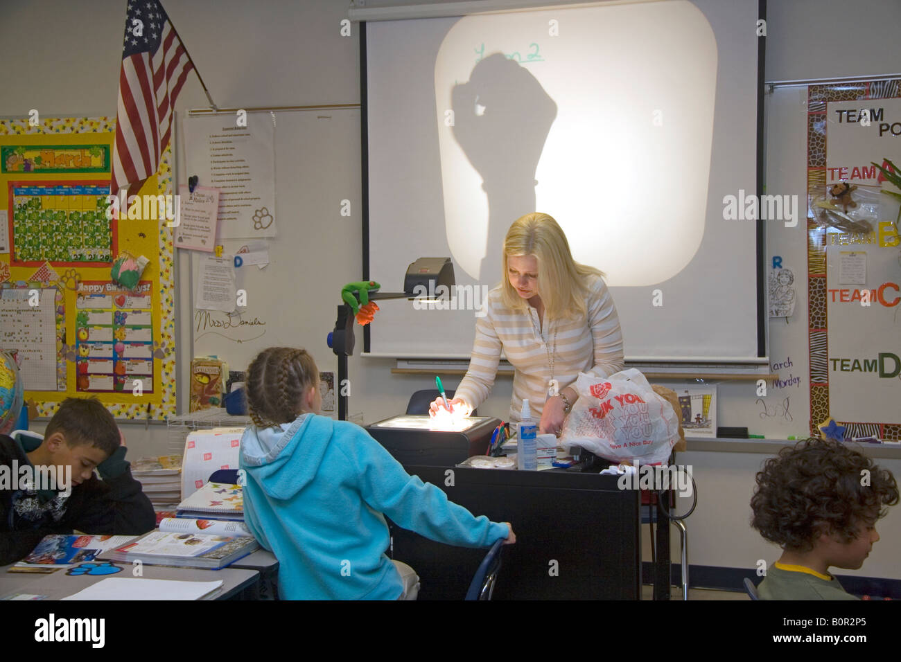 Quarto grado insegnante di scuola elementare usando un proiettore in una classe in Tampa Florida Foto Stock