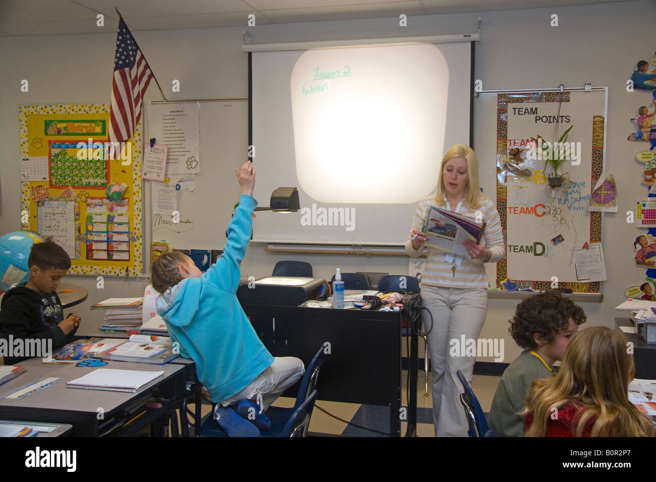 Quarto grado insegnante di scuola elementare utilizza un proiettore in una classe in Tampa Florida Foto Stock