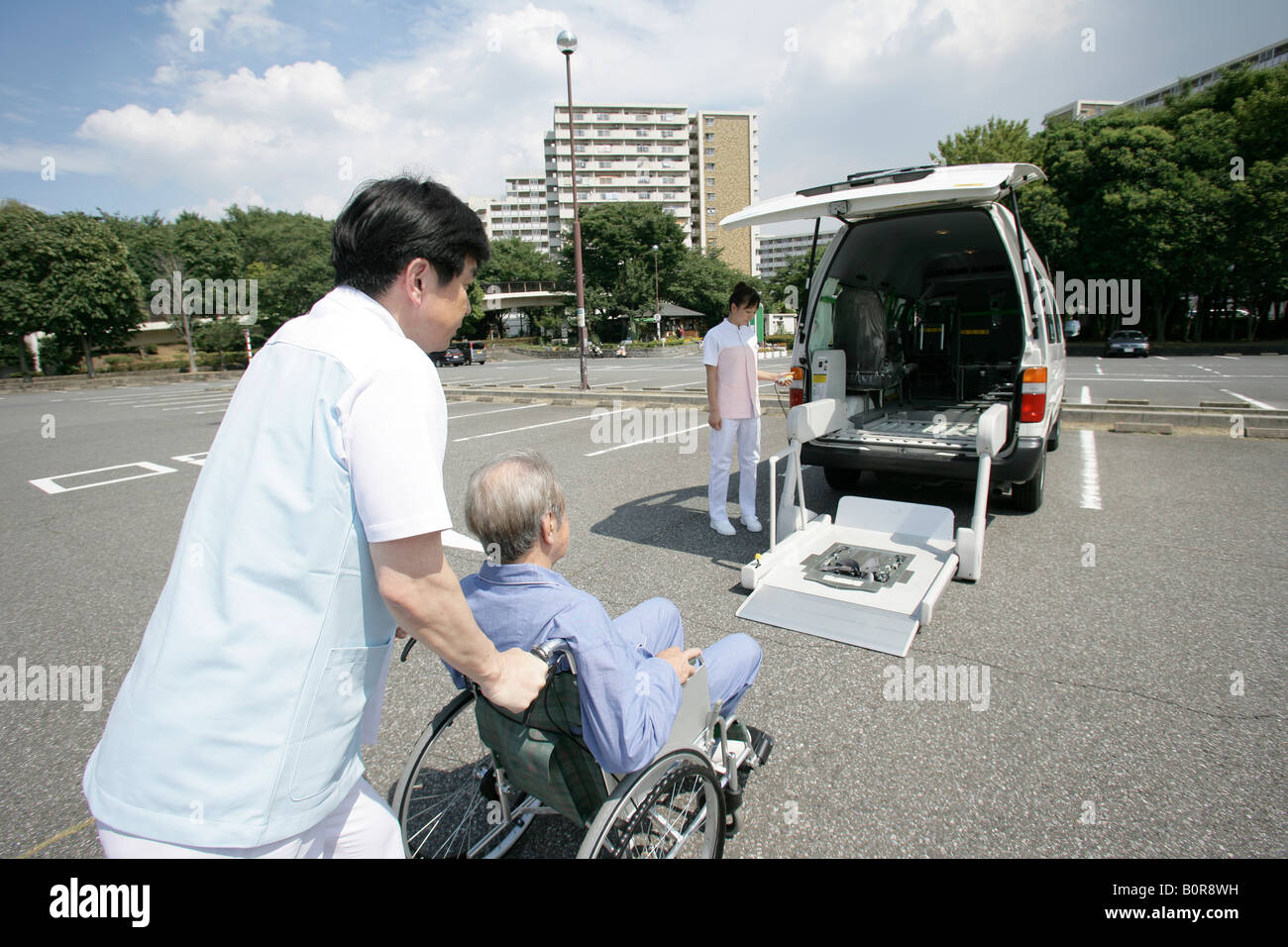 Infermiere spingendo senior uomo in sedia a rotelle verso auto aperto Foto Stock