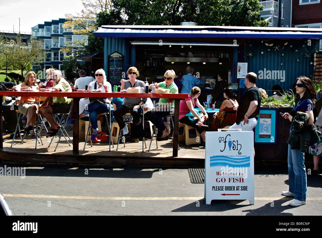 Patroni di un popolare pesce all'aperto e di chip shop che si affaccia l'ingresso a Vancouver è False Creek waterfront. Foto Stock