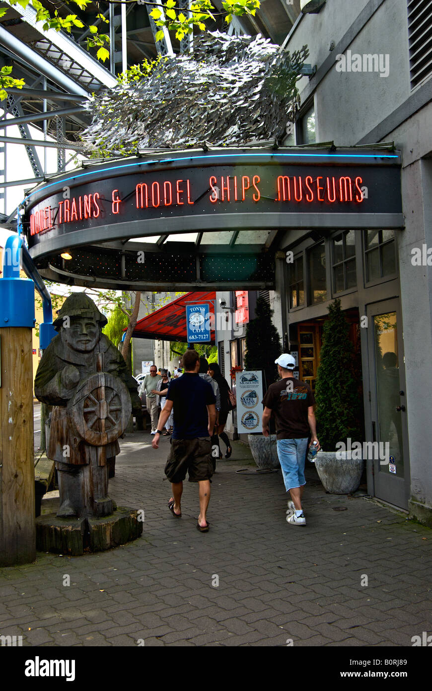 I turisti passeggiano di fronte l'insegna al neon segnando l'ingresso al Granville Island Museum. Foto Stock