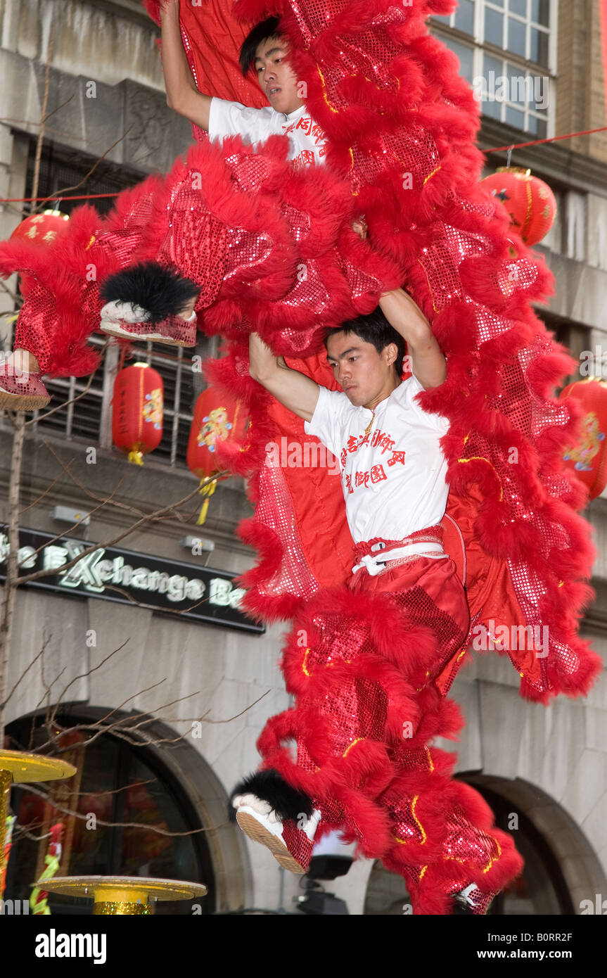 2 dragone cinese e lion dancing acrobati esecuzione di pali in cima al London Chinatown Capodanno cinese Foto Stock