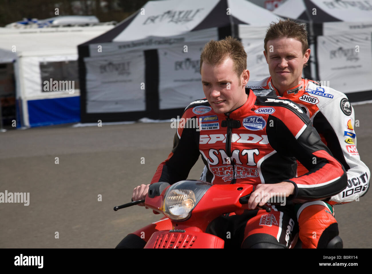 Adam Jenkinson dà John Laverty un ascensore ai box in Bennett s British Superbike Championship a Brands Hatch, in Inghilterra. Foto Stock