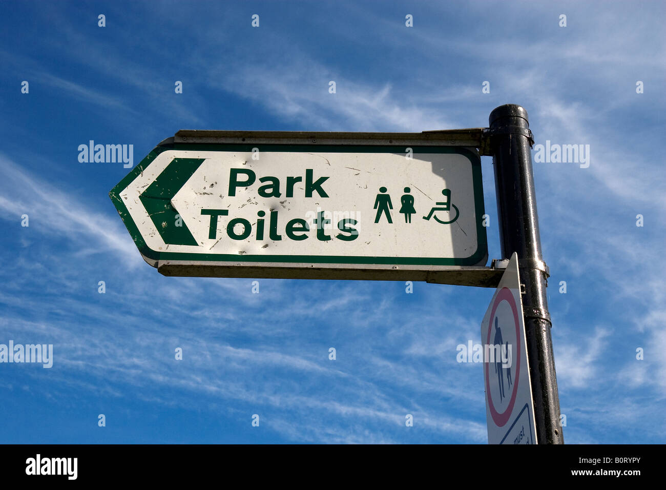 Chiusura del cartello che dice park servizi igienici con i simboli per gli uomini e le donne disabili e su sedia a rotelle Foto Stock