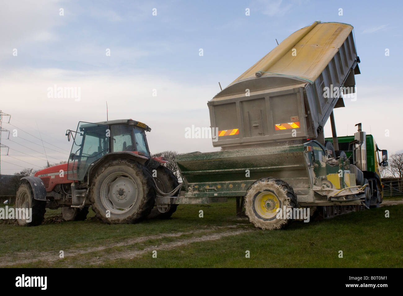 Il caricamento del carro calce su un trattore e dello spanditore in preparazione per lo spandimento sul terreno Lancashre Inghilterra Foto Stock