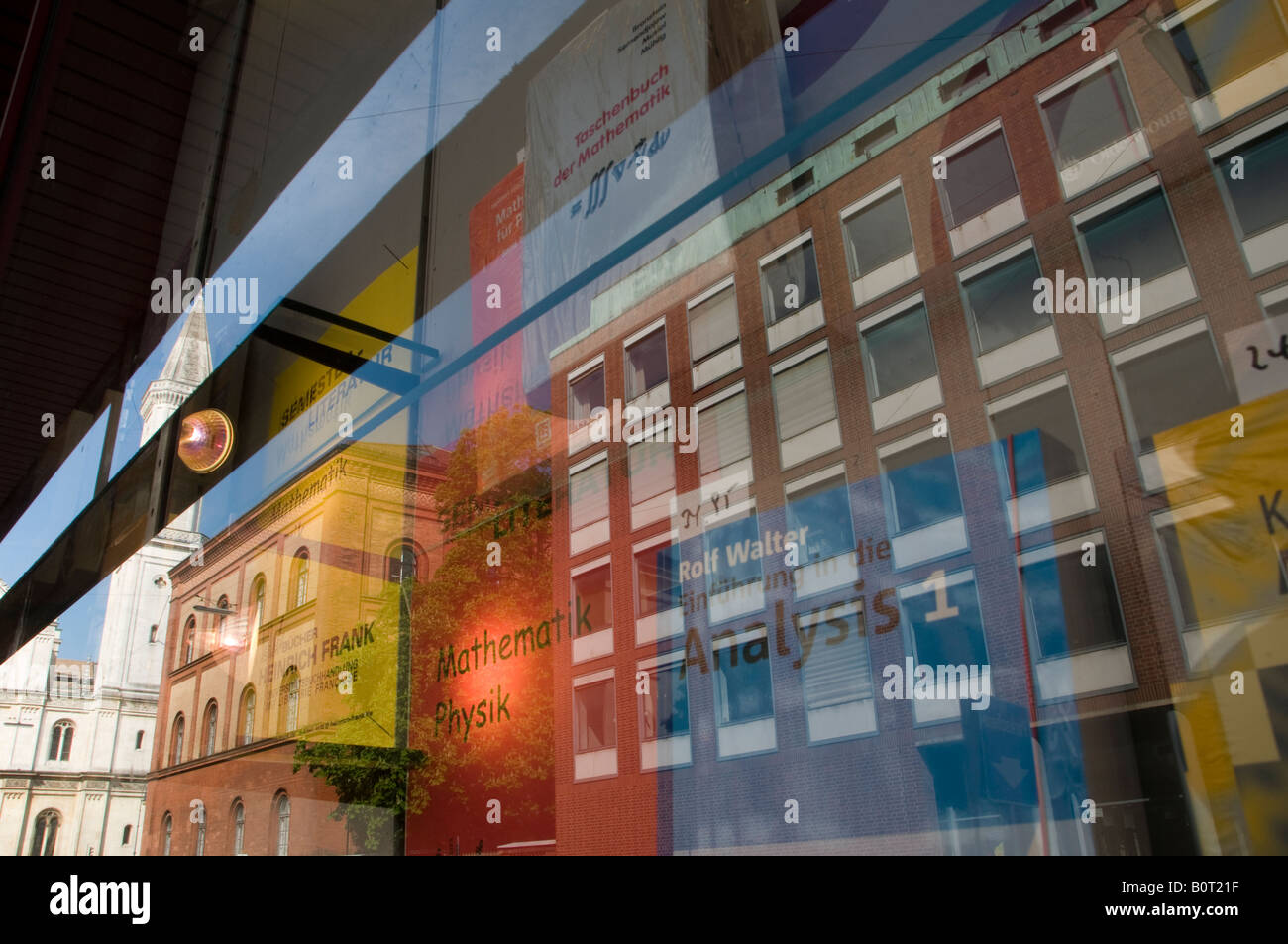 La riflessione di edifici in un libro vetrina di un negozio nella città di Monaco di Baviera La capitale della Baviera Germania Foto Stock