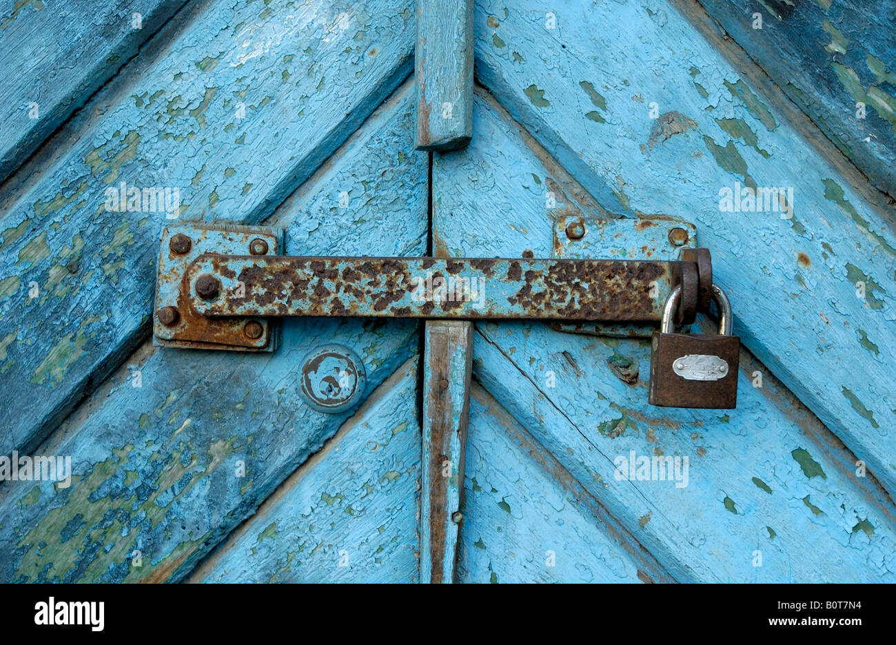 Il lucchetto e rusty lock sul blu gate schede colorate schede vecchio colore blu sono scheggiatura off simbolo dello sfondo Foto Stock