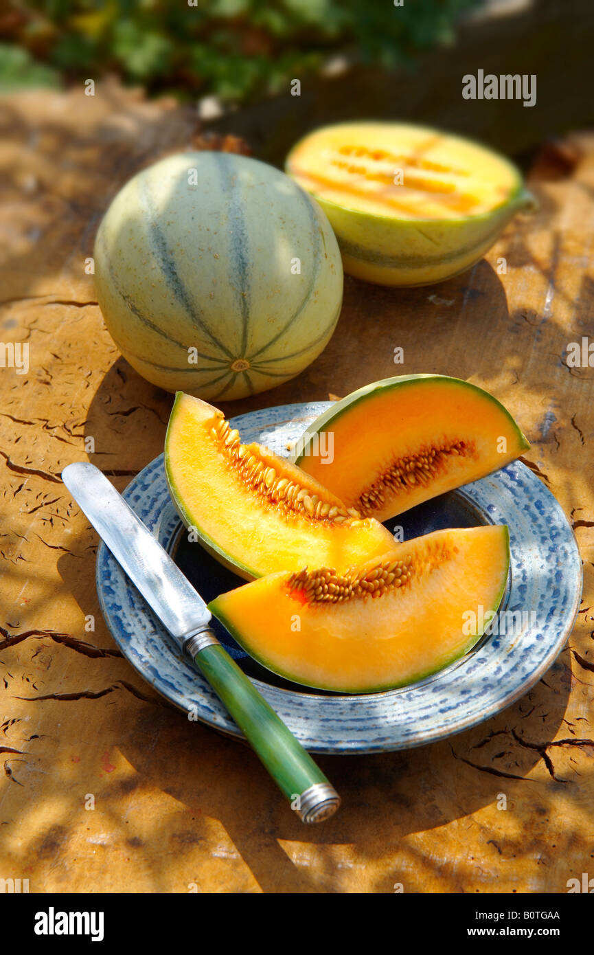 Melone di Cantaloupe appena tagliato su un tavolo in giardino in una giornata di sole Foto Stock