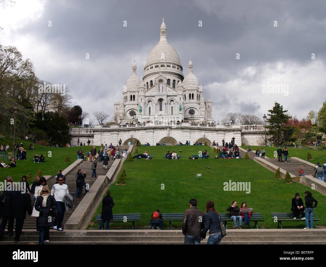 Sacro Cuore Sacro Cuore chiesa in Montmartre Parigi Francia con molti turisti sulle fasi di erba Foto Stock