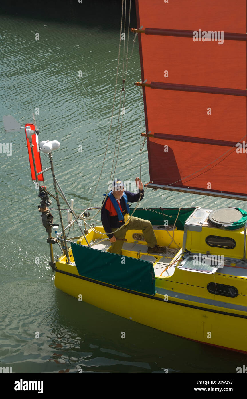 Uomo in barca a vela nella posta indesiderata yacht truccate in partenza dal porto di Scarborough, North Yorkshire, Regno Unito Foto Stock