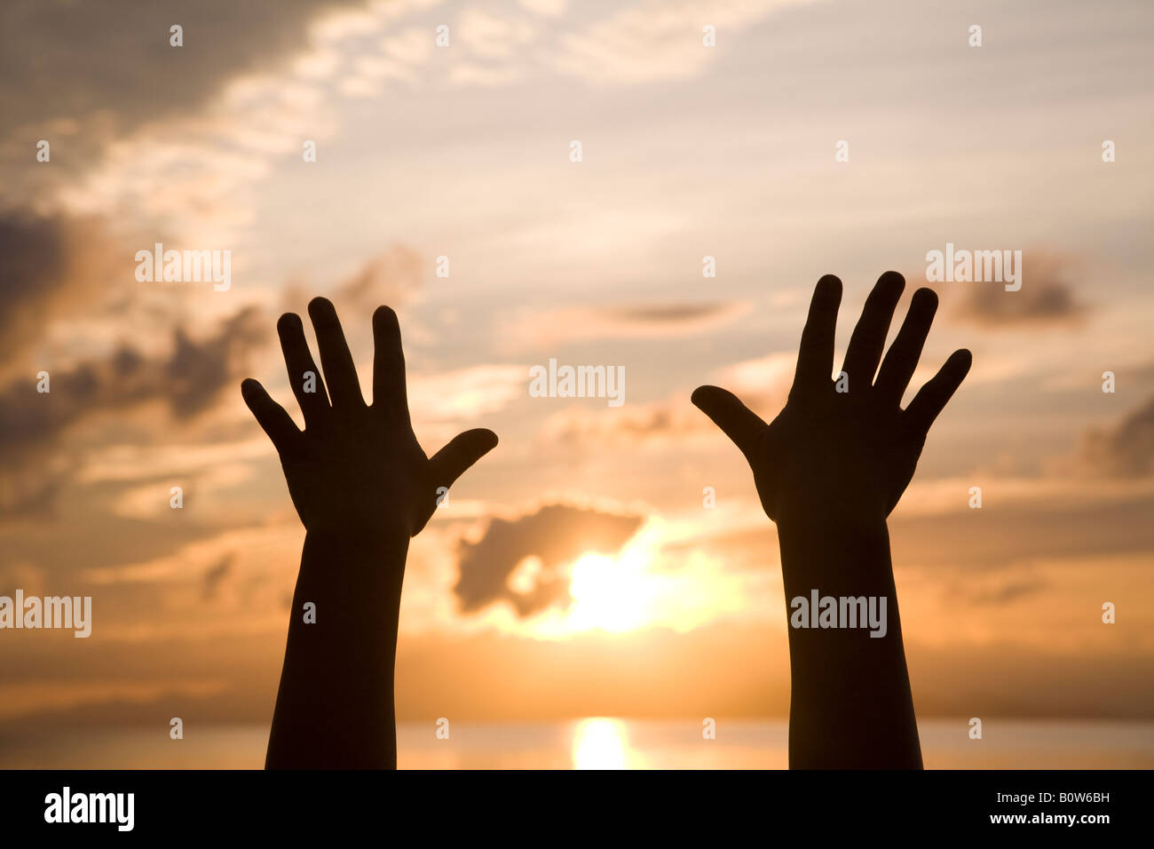 Donna con le mani in mano per raggiungere il cielo Foto Stock