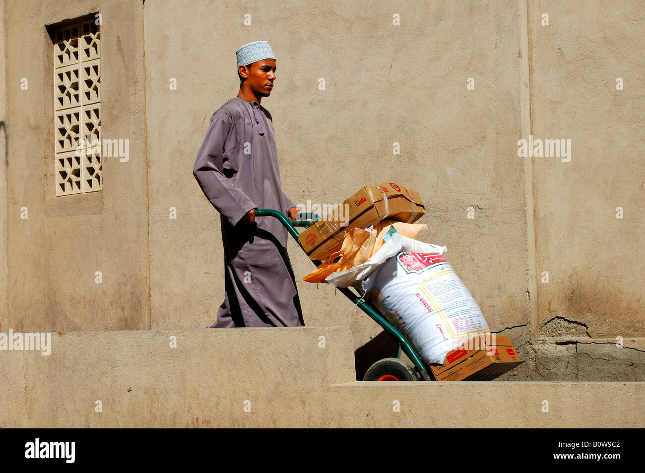 Il trasporto manuale delle merci ad un souk, Nizwa, Oman, Medio Oriente Foto Stock
