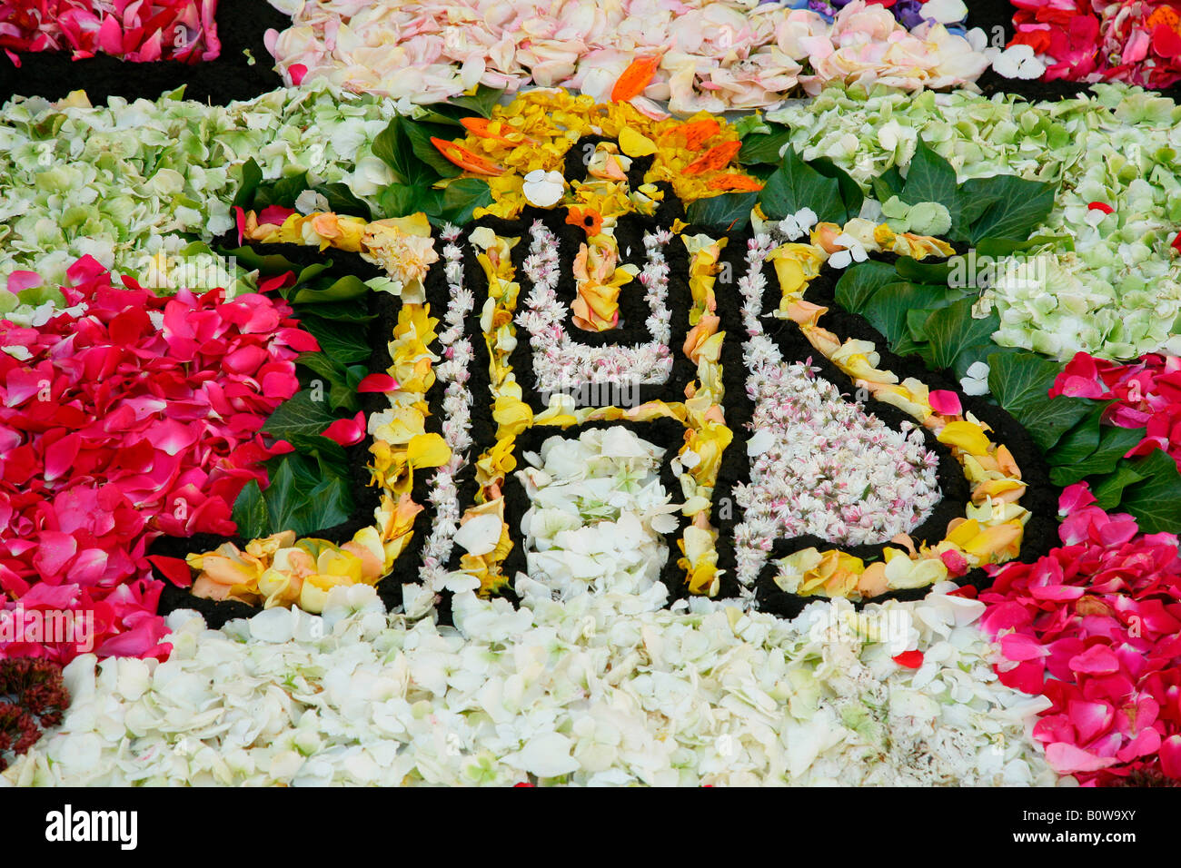 Tappeto di fiori durante la processione del Corpus Domini, monogramma JHS, Gesù Cristo, Muehldorf am Inn, Alta Baviera, Germania, e Foto Stock