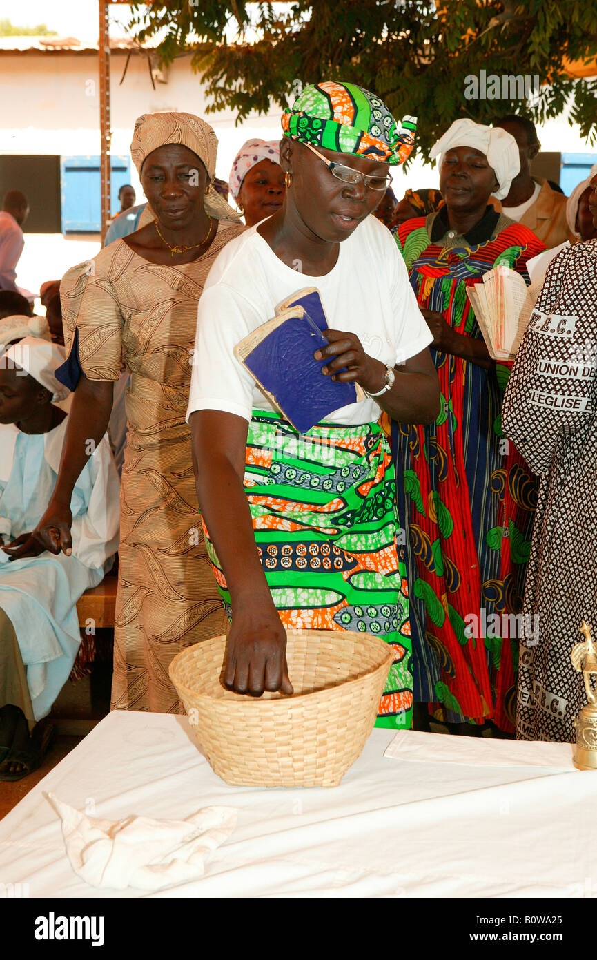 La donna la donazione di denaro a un servizio di chiesa, Garoua, Camerun, Africa Foto Stock