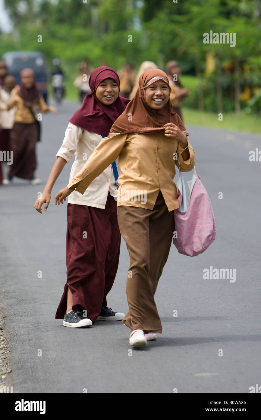 Ragazze musulmane, scolari indossando le loro uniformi a piedi lungo la strada dopo la scuola nei pressi di Mataram, Isola di Lombok, minore S Foto Stock