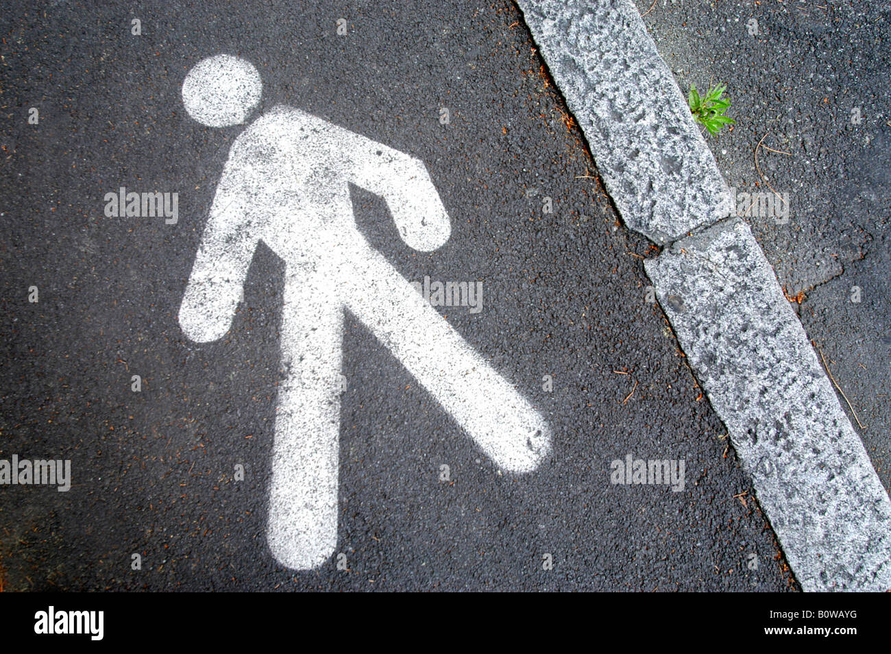 Simbolo pedonale dipinta sul marciapiede Foto Stock