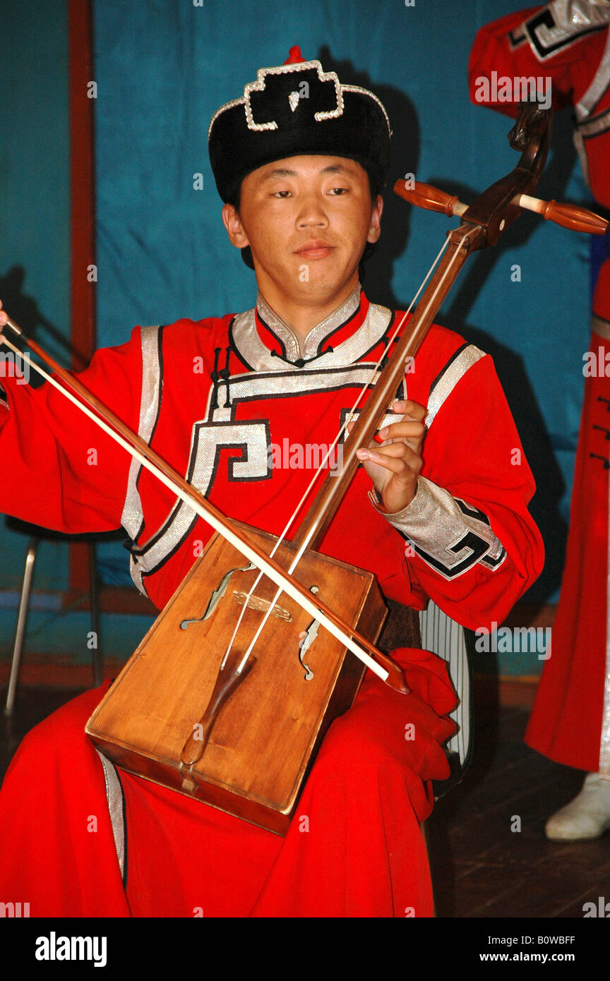 Musicista indossando vestiti tradizionali la riproduzione del morin khuur, matouqin o cavallo-testa fiddle, Mongolia, Asia Foto Stock