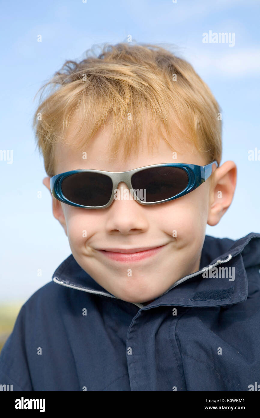 Cinque-anno-vecchio ragazzo che indossa gli occhiali da sole Foto Stock