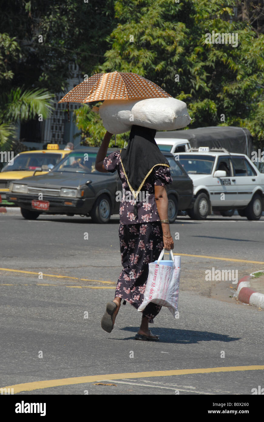 Signora birmano che trasportano merci sulla sua testa, Rangoon, Birmania Foto Stock