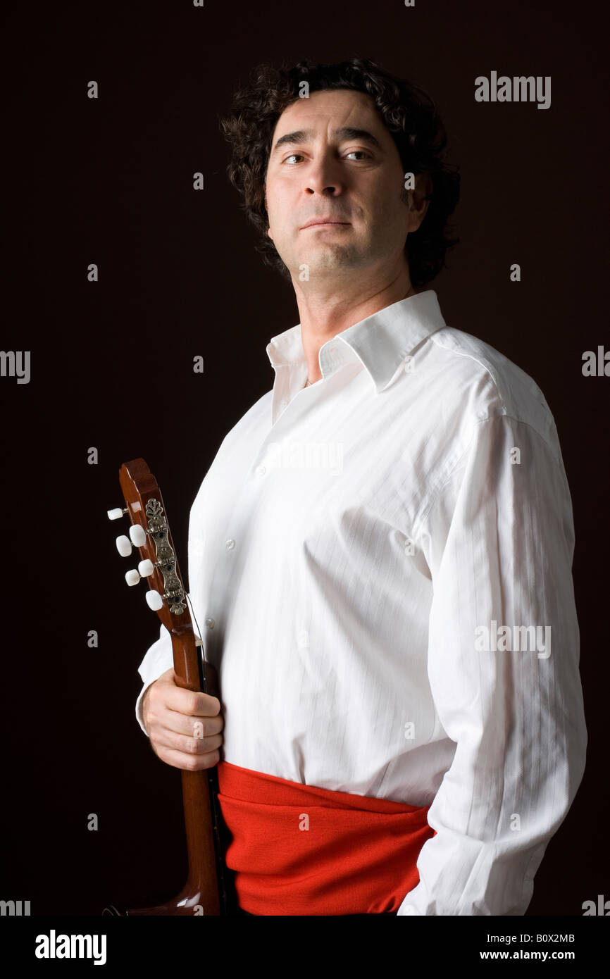 Stereotipato uomo spagnolo in abbigliamento tradizionale tenendo una chitarra acustica Foto Stock