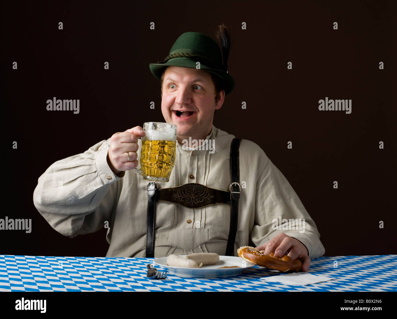 Stereotipi uomo tedesco tenendo una birra e un pretzel Foto Stock