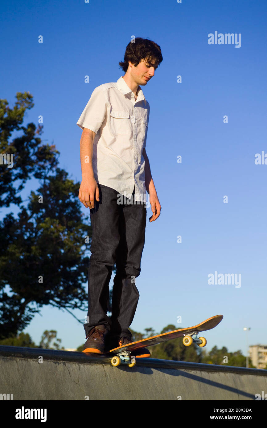 Un guidatore di skateboard in piedi in cima a una rampa Foto Stock