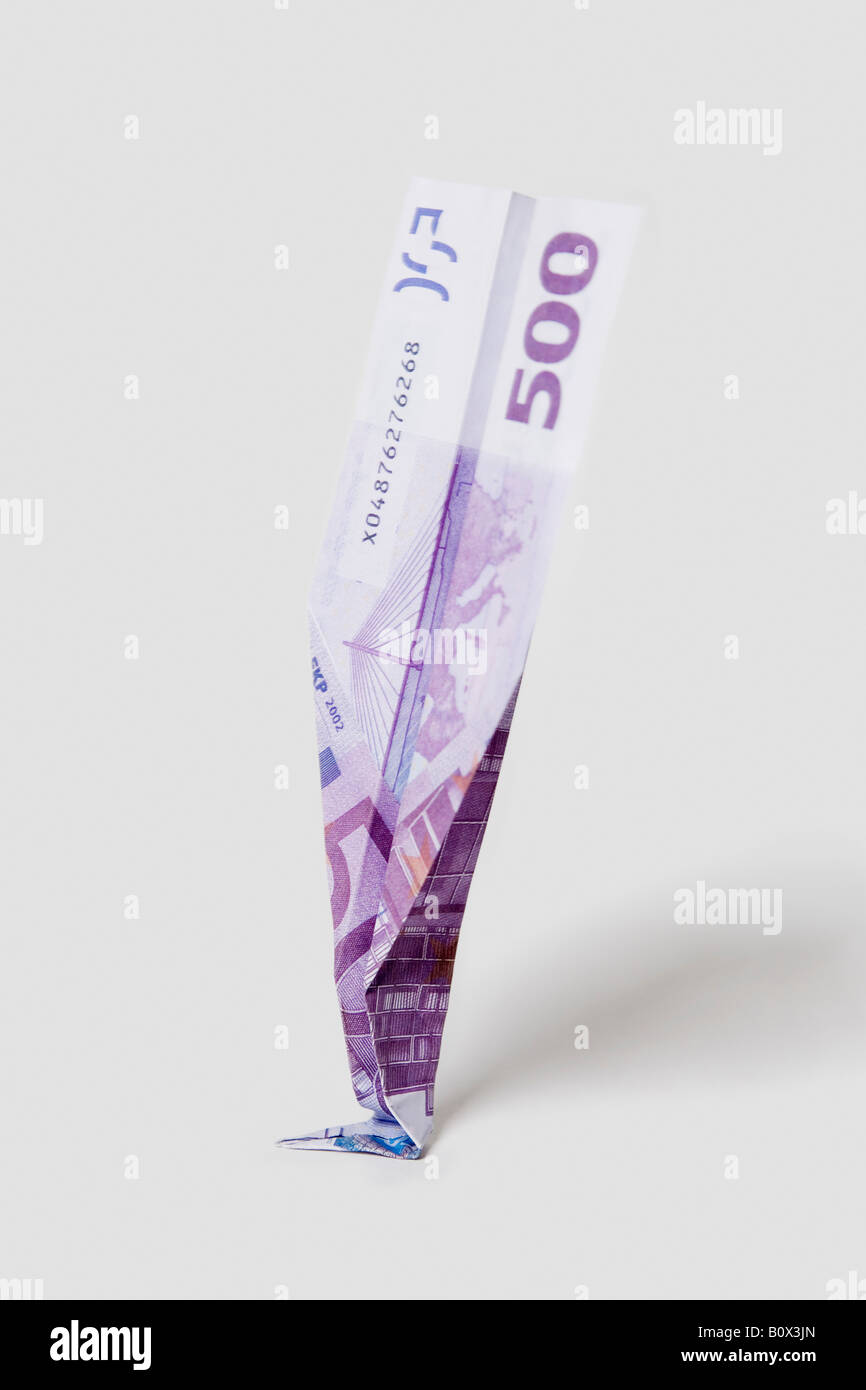 Un aeroplano di carta fatta da una cinquecento di banconote in euro si è schiantato sul suo naso Foto Stock