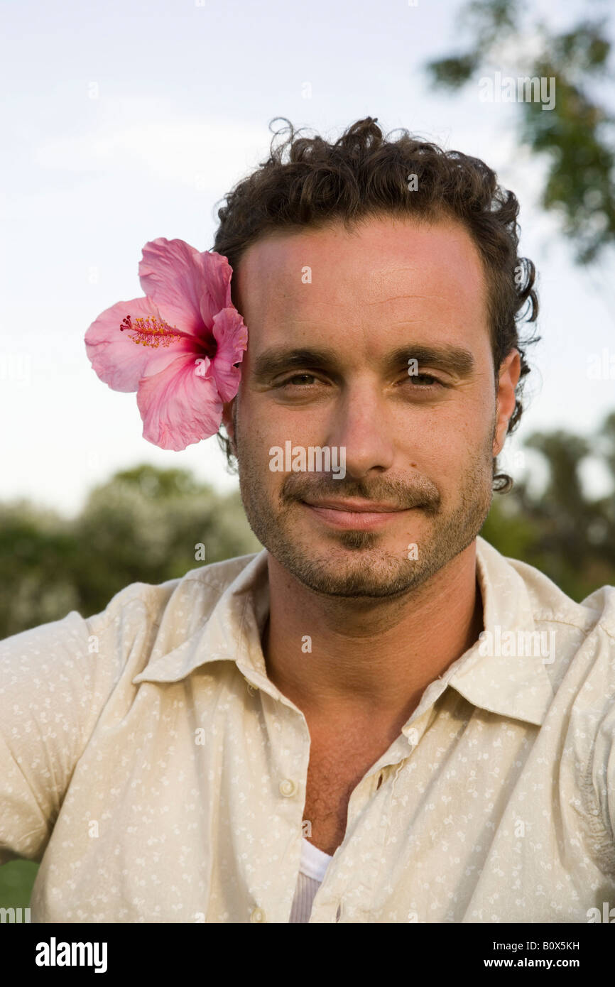 Ritratto di un uomo che indossa un fiore tropicale Foto Stock