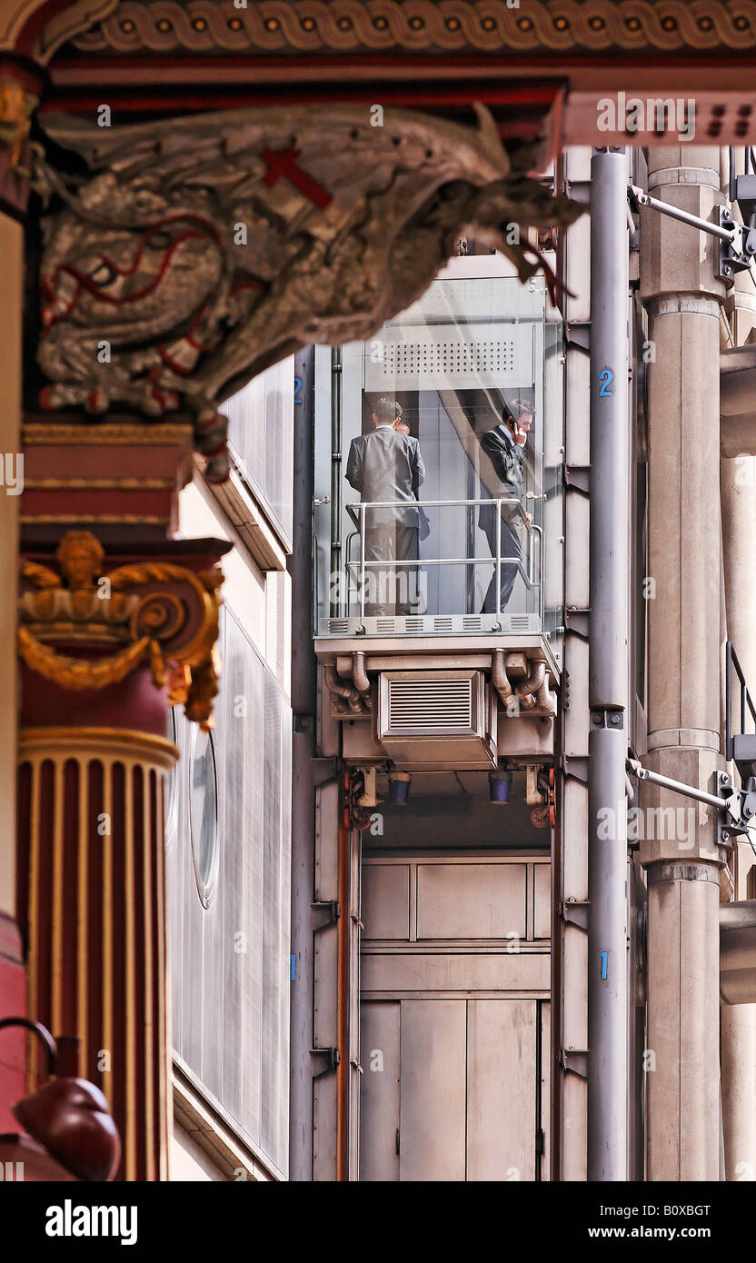 Lloyds mercato assicurativo, il cuore della città di Londra e vicino al mercato Leadenhall. Due uomini in un ascensore su telefoni cellulari Foto Stock